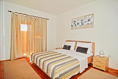 Schlafzimmer mit einem Bett und einem Fenster in der Unterkunft Apartman Nina in Zadar