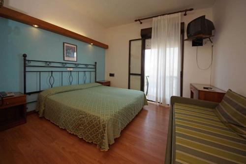 a bedroom with a bed and a chair in it at Hotel President in Lido di Jesolo