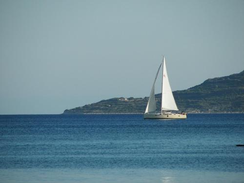 a sailboat in the middle of a large body of water at Theoxenia Chios Apartments in Paralia Agias Foteinis