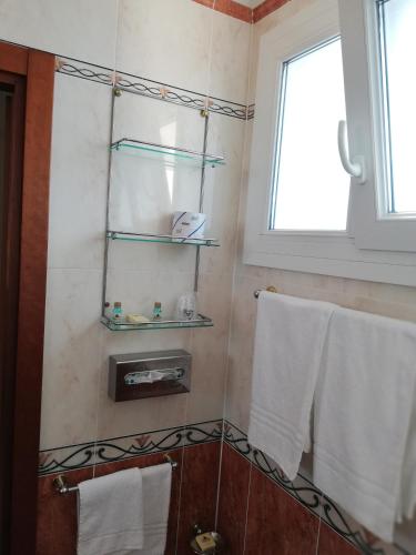 a bathroom with white towels and a window at Hotel Caravelle&MiniCaravelle in Lido di Jesolo