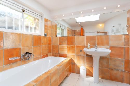a bathroom with a tub and a sink at Haus mit Garten über der Bucht von Cannes in Vallauris