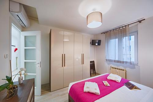 1 dormitorio con 1 cama con manta rosa en Elegant Pol's Loft, en Trieste