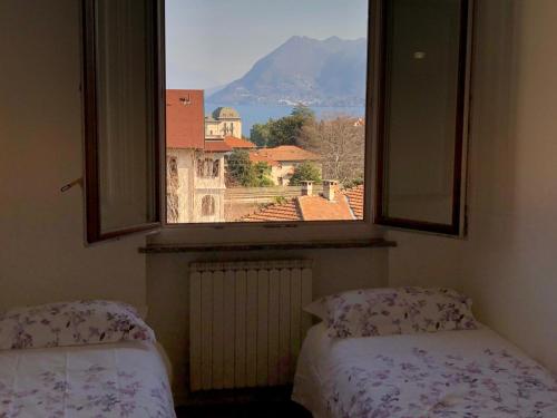 two beds in a room with a window with a view at Beth in Stresa