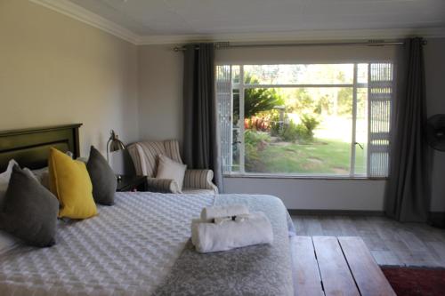 a bedroom with a bed and a large window at Kismet Farm in Muldersdrift
