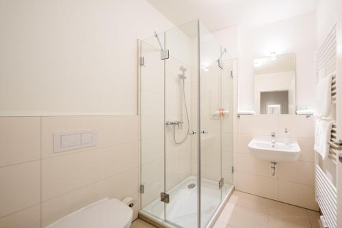 a bathroom with a shower and a toilet and a sink at Haus Rissen Gaestehaus in Hamburg