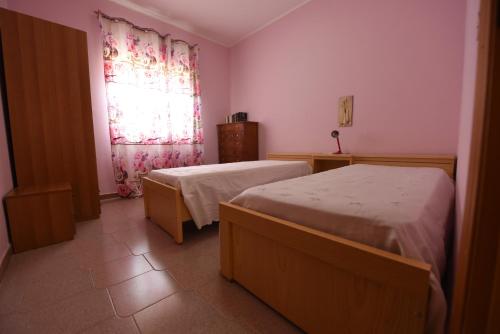 a bedroom with two beds and a window at Villa G.Giuliano in Floridia