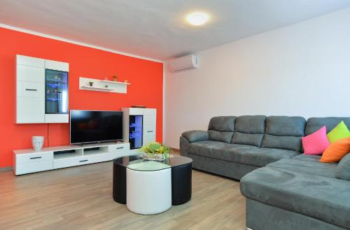 a living room with a couch and a flat screen tv at Apartment Mrgani 1814 in Mrgani