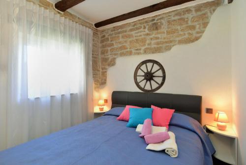 a bedroom with a blue bed with pink and blue pillows at Apartment Mrgani 1814 in Mrgani