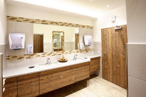 a bathroom with two sinks and a large mirror at Spirklhof in Bodenkirchen
