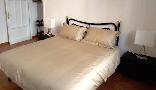 a bedroom with a white bed with two lamps at My Enchanting Roman Holiday in Rome