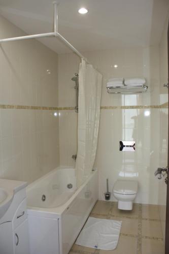 a white bathroom with a tub and a toilet at For You in Odesa