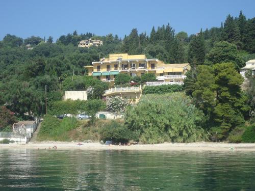 a large house on a hill next to a beach at Meltemi Appartments in Perama