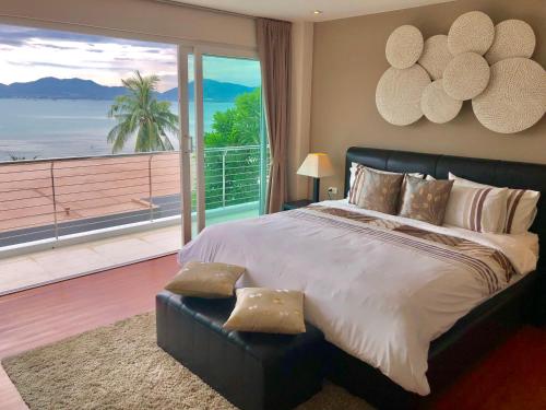 una camera con un grande letto e una grande finestra di D-Lux 4 bed beachfront apartment with sea view a Panwa Beach