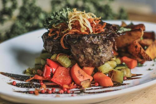 a plate of food with meat and vegetables on a table at Gasthof Kornbachtal in Gefrees