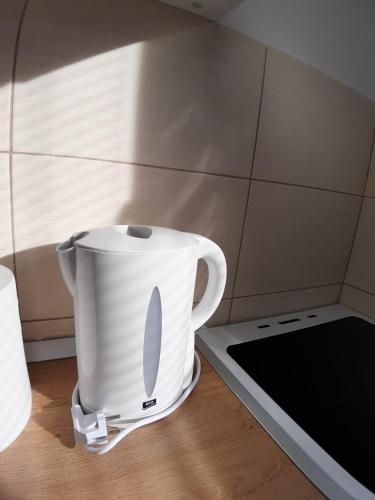 a white pot sitting on top of a stove at Apartment Teodora in Belgrade