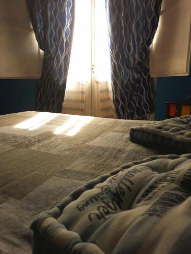 a bed in a bedroom with a window with curtains at Bio Agriturismo Valle dei Calanchi in Castiglione in Teverina