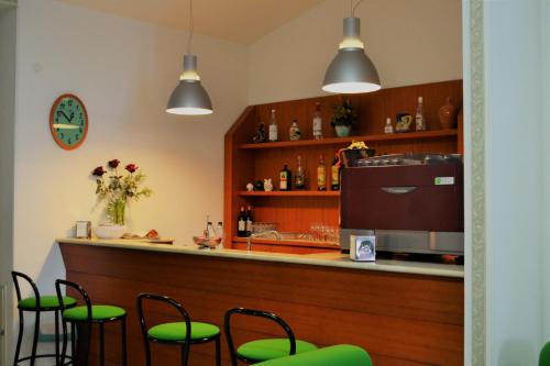eine Bar mit grünen Stühlen vor einer Theke in der Unterkunft Centro di Spiritualità Madonna della Nova in Ostuni