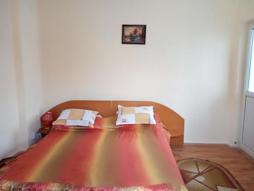 ein Bett mit einer Regenbogen-Bettdecke darauf in einem Zimmer in der Unterkunft Casa Olanescu in Băile Olăneşti