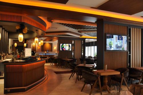 a restaurant with tables and chairs and a bar at Hotel Borea in Peje