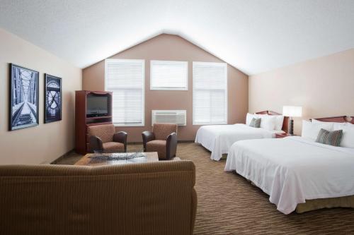 GrandStay Residential Suites Hotel - Eau Claire tesisinde bir odada yatak veya yataklar