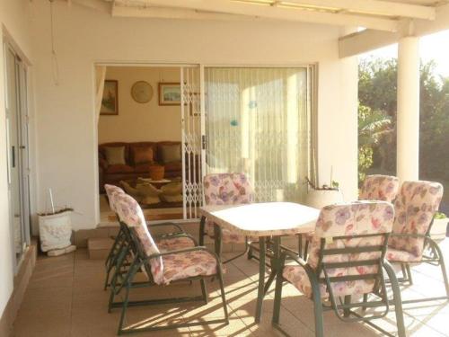 een veranda met een tafel en stoelen en een bank bij Blue Haven in Ramsgate