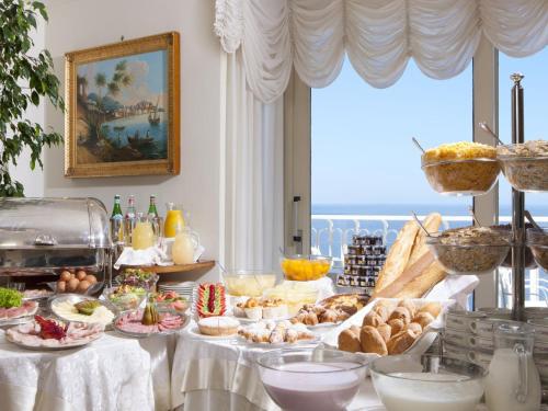a buffet of food on a table in a room at Hotel Corallo Sorrento in Sant'Agnello