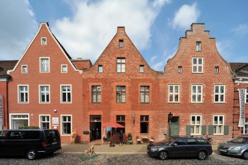 un grand bâtiment en briques rouges avec deux tours dans l'établissement Apartmenthaus im holländischen Viertel, à Potsdam