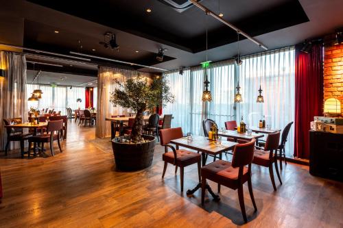 um restaurante com pisos e mesas e cadeiras de madeira em pentahotel Derby em Derby
