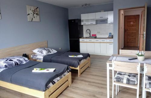 une petite chambre avec deux lits et une cuisine dans l'établissement Noclegi na Heweliusza, à Sanok