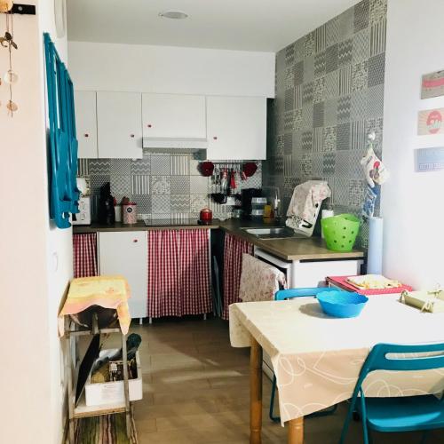 a kitchen with white cabinets and a table at CASA BIKAS in Barão de São Miguel