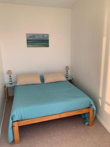 a bed in a white room with two night stands at Le COURLIS vue panoramique sur la mer, balcons in Ault
