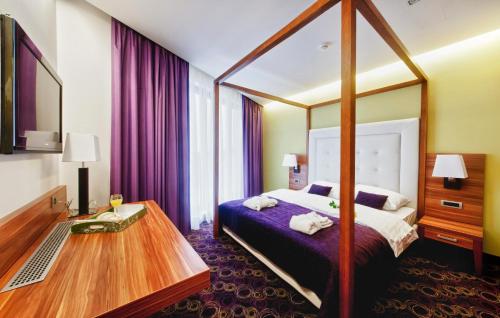 Habitación de hotel con cama y mesa de madera en Hotel Sport en Ivanić-Grad