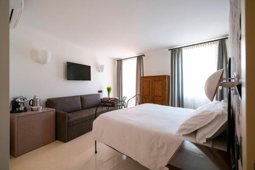 a bedroom with a bed and a couch at Antica Pusterla Relais de Charme in Vicenza