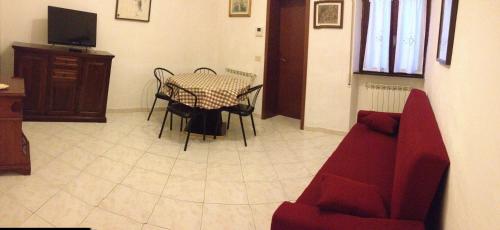 a living room with a table and a red couch at Foscolomare in Viareggio