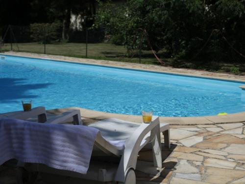 a table and chairs next to a swimming pool at Chalet near Lake and Pool in Quend-Plage in Quend