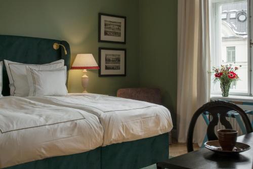 a bedroom with a bed and a chair and a window at The Sparrow Hotel in Stockholm