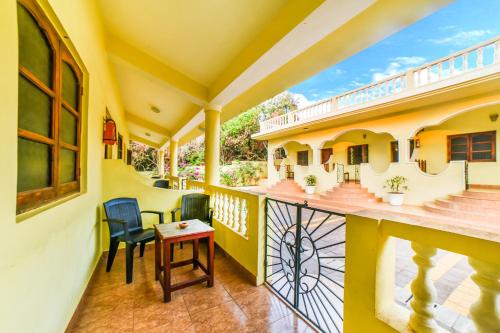 a balcony of a house with two chairs and a table at FabHotel La Pablo - Chapora Fort view in Vagator