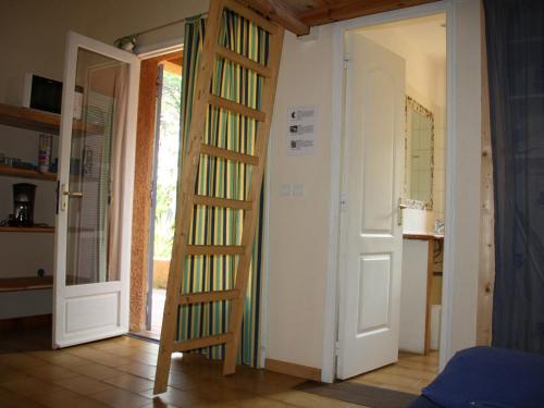 a room with a wooden ladder leading to a door at Beautiful holiday home near the beach in Santa-Lucia-di-Moriani