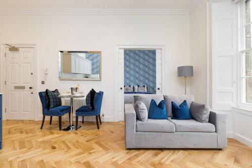 uma sala de estar com um sofá e uma mesa em Luxury Renovated 1 Bed Nr St James - Super Central em Edimburgo