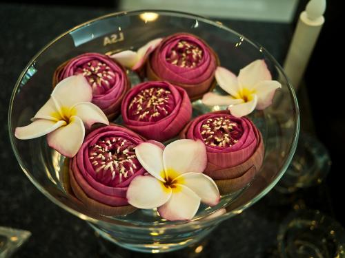 a glass bowl filled with pink and white flowers at G9bangkok in Bangkok