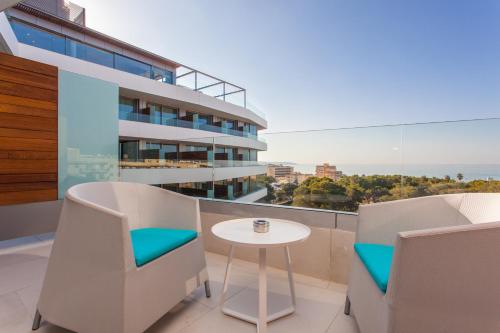 a balcony with a table and chairs and a building at Iberostar Selection Llaut Palma- Adults Only in Playa de Palma