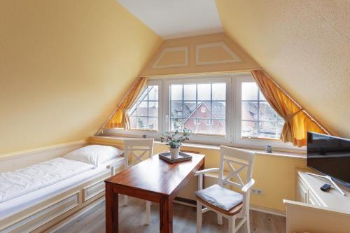 a room with a bed and a table and a window at Priel-Hüs in List