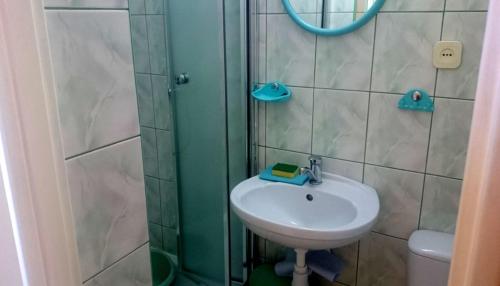 La salle de bains est pourvue d'un lavabo et d'une douche. dans l'établissement Dom Wczasowy Magdalena, à Władysławowo
