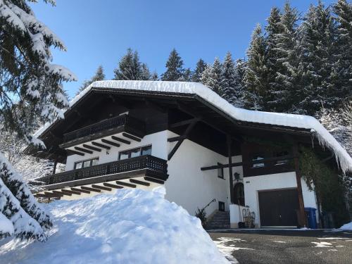 ein schneebedecktes Gebäude mit einem Stapel Schnee in der Unterkunft Haus Margarete & Landhaus Karin in Zwiesel