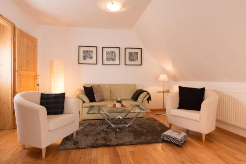 a living room with a couch and two chairs at Davidshof, Bed & Breakfast in Schneverdingen