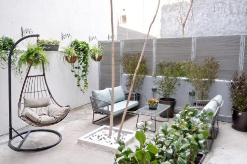 a patio with chairs and potted plants at Hercules Residence in Athens