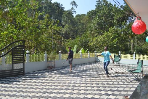 two men playing a game of tennis on a patio at Arabian Nights Munnar Pool Villa in Munnar