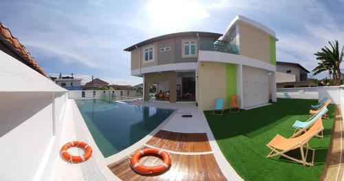 uma casa com piscina e algumas cadeiras em Sunshine Lodge em Kuantan