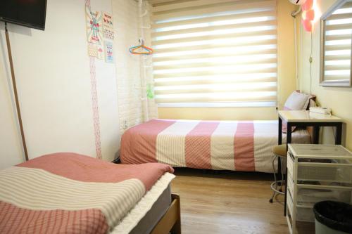 Una cama o camas en una habitación de Hongdae Style Guesthouse