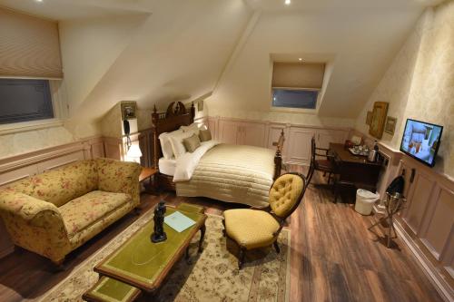um quarto com uma cama, um sofá e uma mesa em The Aston Tavern em Birmingham